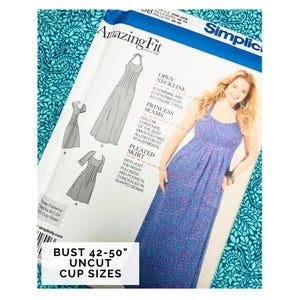 Könnte beinhalten: Ein Simplicity Amazing Fit Schnittmuster. Das Muster zeigt ein Kleid mit offenem Ausschnitt, Prinzessnähten und einem plissierten Rock. Das Muster umfasst Brustgrößen von 107-127 cm und ist ungeschnitten.