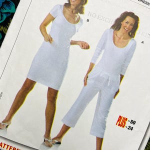 May include: A sewing pattern envelope featuring two white garment styles: a short-sleeved dress and a long-sleeved top paired with cropped trousers featuring a drawstring waist. The text includes "KLEID", "T-SHIRT", "ROBE", "SHIRT", "DRESS", and "PLUS -50 -24".