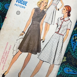 Op de afbeelding: Een Vogue naaipatroon-envelop met illustraties van twee jurkstijlen. De ene is een mouwloze donkere jurk met een ingesneden halslijn, de andere is een jurk met stippen en een jasje met kraag en korte mouwen. Tekst bevat BUST 34 en 60p.