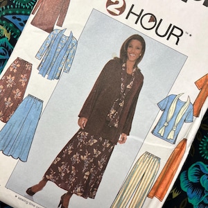 May include: A Simplicity 2 Hour sewing pattern envelope featuring illustrations of various garments including a long-sleeved brown top, a floral skirt, a blue cardigan, a blue t-shirt with a scarf, and striped trousers, with text reading 2 HOUR.
