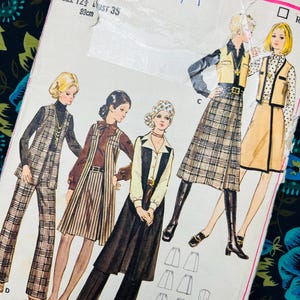 Op de afbeelding: Vintage naaipatroon met illustraties van damesmode uit de jaren 70. Het patroon bevat ontwerpen voor broekpakken, rokken en jurken. De maat is 12 1/2, met een borstomvang van 89cm. Het patroonnummer is 5949.