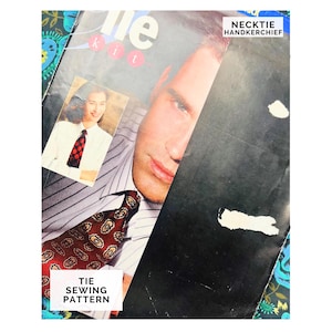 Op de afbeelding: Een vintage stropdassenkit met het gezicht van een man en een vrouw met een stropdas. De kit bevat een patroon voor het naaien van een stropdas en de woorden "Necktie Handkerchief". De stropdas op de afbeelding heeft een bruin en goud patroon.
