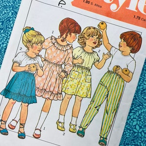 May include: A vintage sewing pattern with illustrations of children's clothing. The pattern shows four children in different outfits, including dresses and striped trousers. The pattern is labelled "Style" and includes size and chest measurements of 53 cm.