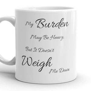 Puede incluir: Taza de café de cerámica blanca con texto negro que dice "My Burden May Be Heavy, But It Doesn't Weigh Me Down."