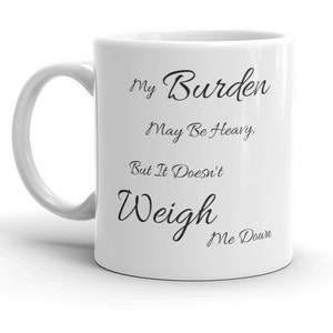 Puede incluir: Taza de café de cerámica blanca con texto negro que dice "My Burden May Be Heavy, But It Doesn't Weigh Me Down."