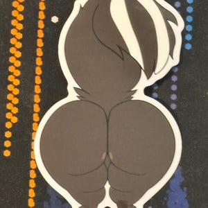 May include: A white sticker with a cartoon skunk with a black and white striped tail. The skunk is facing away from the viewer and has a large, round backside.