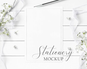 5x7 Stationery Mockup Styled with rustic wood, textured paper, flowers, white ribbon, and white wood pencil on a white wood background.