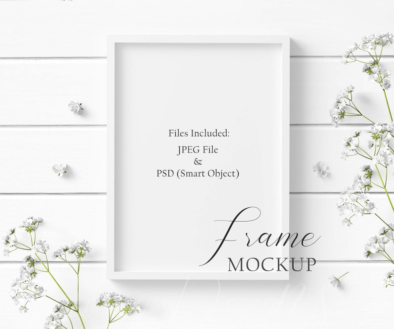 May include: A white rectangular frame mockup with the text "Files Included: JPEG File & PSD (Smart Object)" and "frame MOCKUP". The frame is surrounded by white flowers and rests on a white wooden surface.