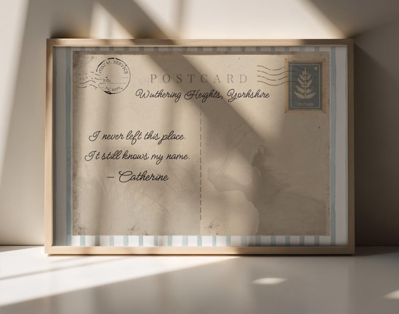 May include: Framed vintage postcard print with the text "Wuthering Heights, Yorkshire." The postcard features a stamp and postmark, with the quote "I never left this place. It still knows my name. - Catherine."