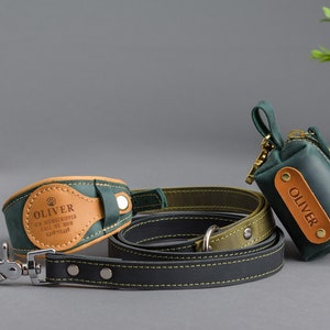 May include: A matching dog collar, leash, and waste bag set in dark green and black leather. The collar and waste bag feature a tan leather patch with the name "OLIVER" and contact information. The leash has a silver-colored clasp.