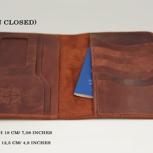 K&ouml;nnte beinhalten: Brauner Leder-Reisepass-Etui mit Kompass-Design und mehreren Kartenf&auml;chern. Das Etui misst 18 cm in der L&auml;nge und 12,5 cm in der Breite.
