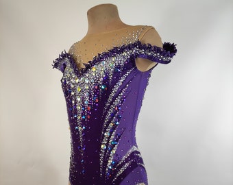 May include: A purple leotard with a sheer mesh overlay and a crystal design. The leotard has a V-neckline and short sleeves.