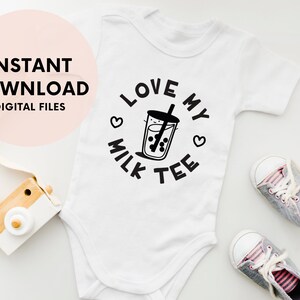 May include: White baby onesie with black text that says "I love my milk tea" with a graphic of a cup of boba tea.