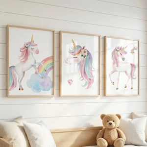 May include: Three framed wall art prints featuring watercolor illustrations of unicorns. The left print shows a unicorn with a rainbow and cloud. The center print depicts a unicorn head with a diamond. The right print shows a standing unicorn.