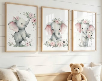 May include: Three framed wall art prints featuring watercolor illustrations of baby elephants. Each elephant is depicted in a soft gray tone with pink ears, adorned with floral crowns or bouquets in shades of pink, white, and green.