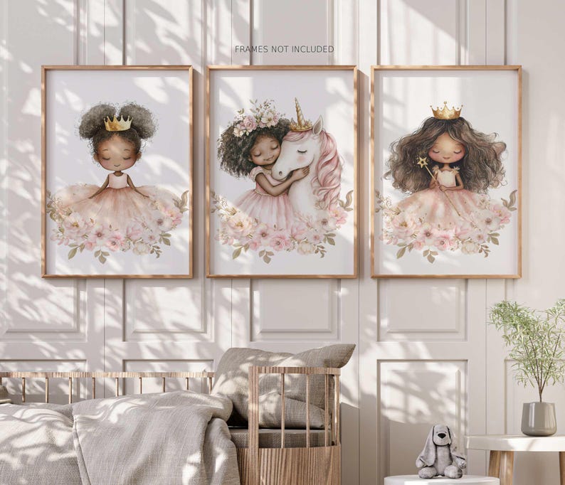 May include: Three framed art prints featuring illustrations of girls in princess dresses. The prints have a soft color palette of pink, peach, and gold. One print shows a girl with a crown, another with a unicorn, and the third with a wand.