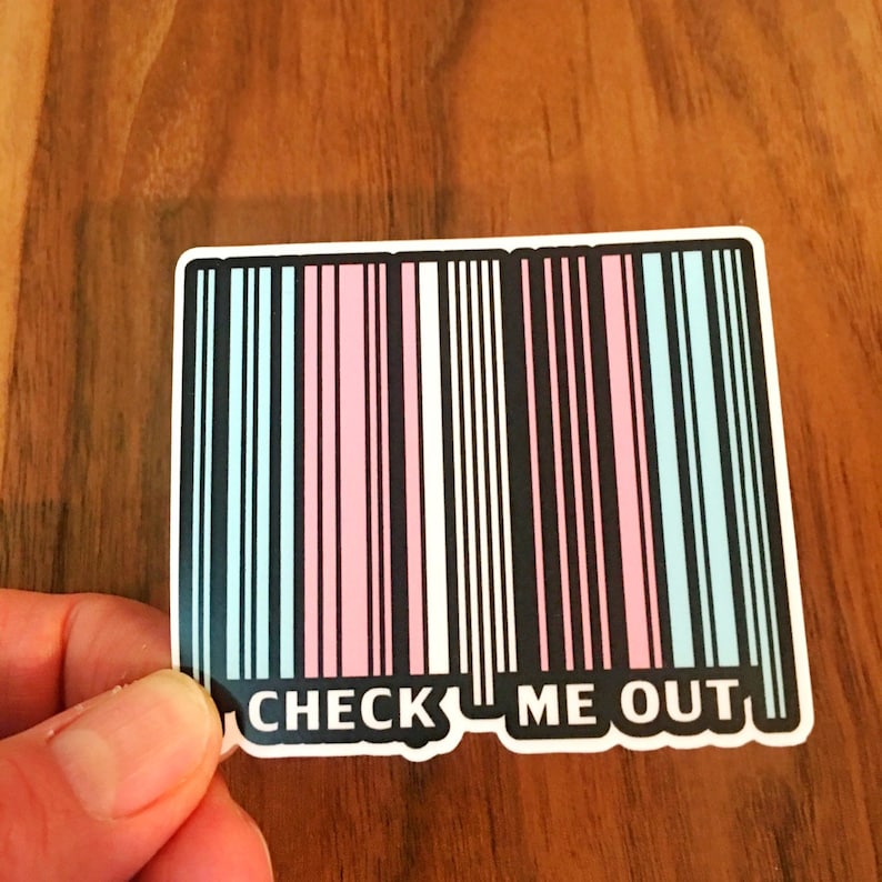 May include: A sticker with a barcode design in pink, blue, and black colors. The barcode has the text "CHECK ME OUT" printed below it.