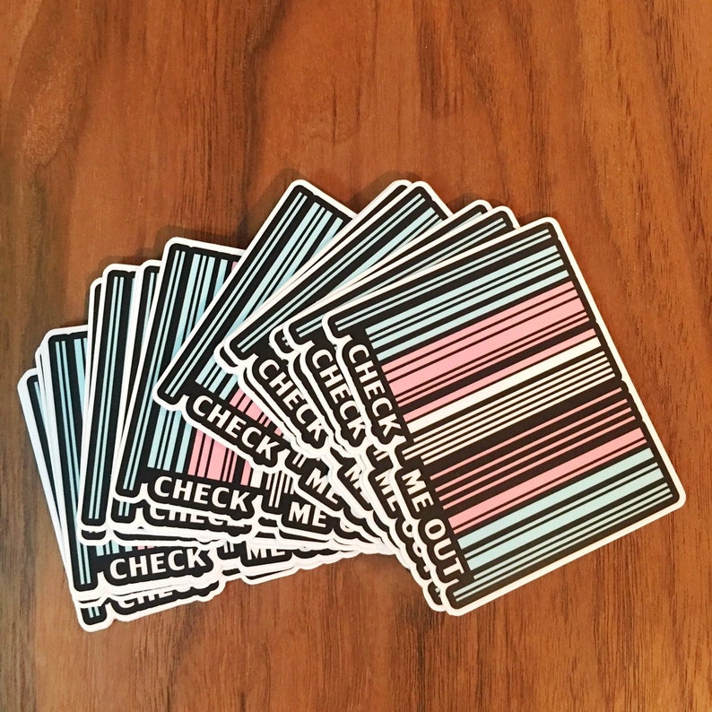 May include: A stack of stickers with a barcode design and the text "CHECK ME OUT" in black text. The barcode is in the colors of the transgender pride flag: light blue, pink, and white.