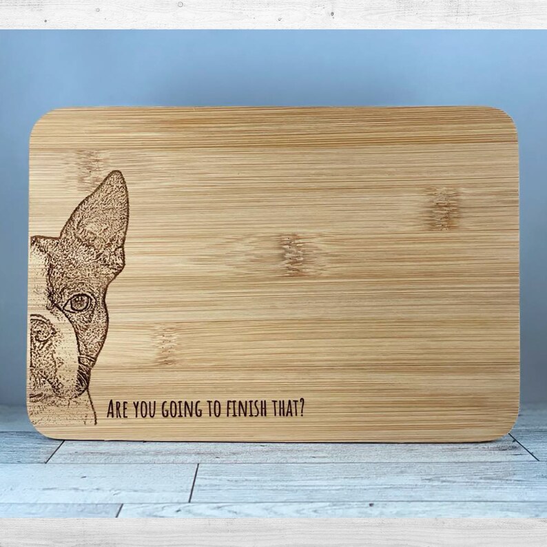 K&ouml;nnte beinhalten: Ein Schneidebrett aus Holz mit einem lasergravierten Bild eines franz&ouml;sischen Bulldoggen, der &uuml;ber den Rand schaut. Der Text "Are you going to finish that?" ist unter dem Bild graviert.