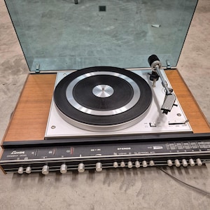 May include: A rustic wooden sign with the text "Welcome to our home" in white lettering. The sign has a distressed finish and a simple, inviting design, ideal for front door decor.