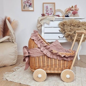 Wiklinowy wózek dla lalek z drewna bukowego i wikliny w kolorze NATURALNYM z pościelą i wstążką DUSTY PINK. Niemalowany