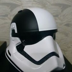 Puede incluir: Un casco blanco y negro con diseño de Stormtrooper. El casco tiene una visera negra y una máscara facial blanca con detalles negros.