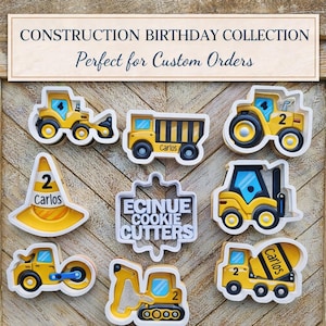 May include: A selection of yellow and white construction-themed cookie cutters, featuring a range of vehicles such as a dumper truck, tractor, and cement mixer. Some cutters are labelled with the name "Carlos" and the number "2". The text "ECINUE COOKIE CUTTERS" is also present.