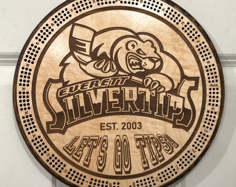 May include: A wooden circular game board with a brown bear logo and the text "Everett Silvertips Est. 2003 Let's Go Tips!" The board has a numbered grid around the edge.