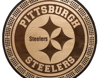 May include: A wooden game board with a black and gold Pittsburgh Steelers logo in the center. The board is surrounded by a circle of numbers from 1 to 120, with the words "Start" and "Finish" at the bottom.