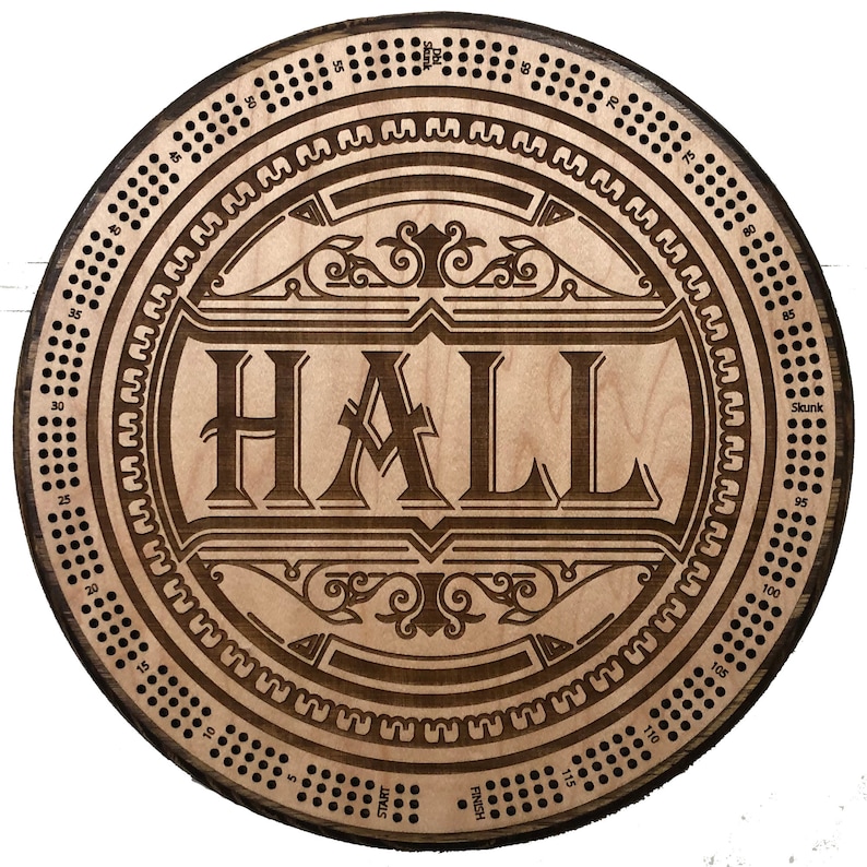 May include: A wooden game board with a circular design. The board has a central area with the word "HALL" in a decorative font. The outer edge of the board has a series of numbers and dots.