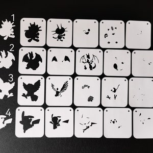May include: A set of 16 white plastic stencils featuring different Pokemon characters. The stencils are numbered 1 through 4 and each number has four different stencils. The stencils are designed for use with paint or other crafting materials.