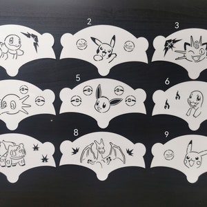 May include: Nine white stencils with black outlines of different Pokemon characters. The stencils are numbered 1 through 9.