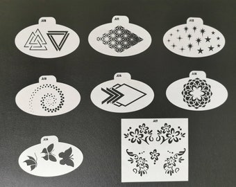 May include: Set of 10 white plastic stencils with various geometric and floral designs. The stencils are labeled A11 through A18.