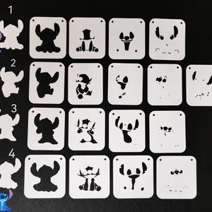 May include: Set of 16 white plastic stencils featuring different designs of the cartoon character Stitch from the Disney movie Lilo & Stitch. The stencils are numbered 1 through 4.