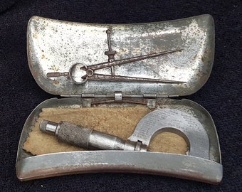 A nice example of vintage micrometer and a set of clippers in a vintage storage tin