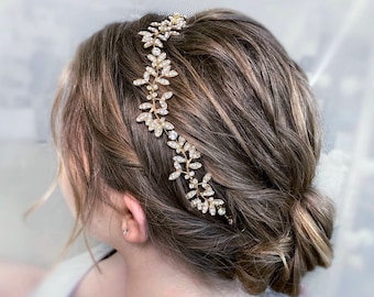 May include: A gold hair comb with clear rhinestones in a leaf design. The comb is worn in a woman's hair.