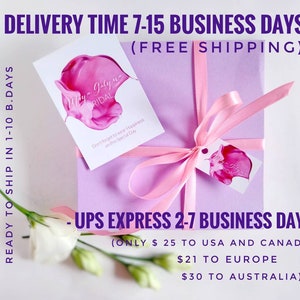 May include: A pink gift box tied with a pink ribbon. The box is wrapped in a light purple paper with a white tag that says "Maya Galyne Bridal" and "Don't forget to wear Happiness on this Special Day". The box is sitting on a white surface with a white flower.