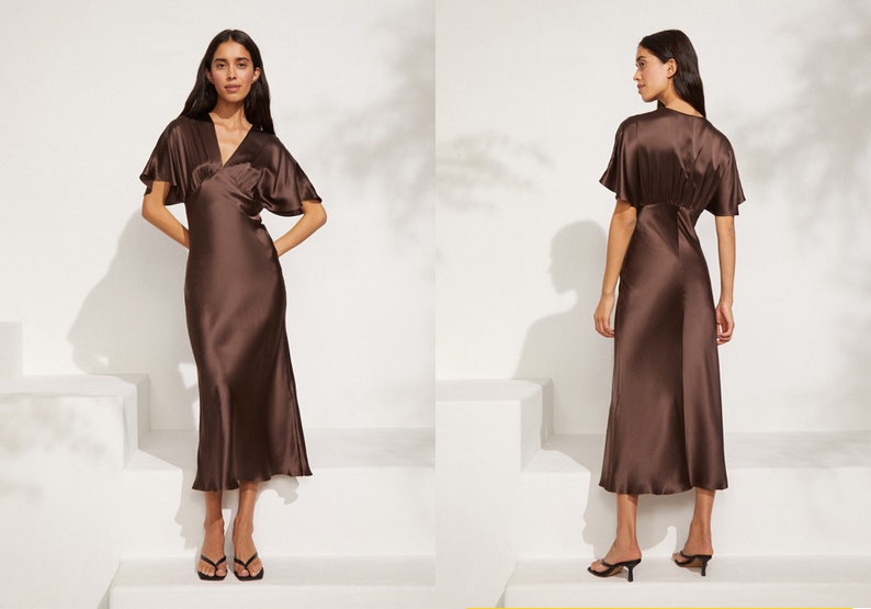 May include: A brown satin midi dress with a V-neckline and short sleeves. The dress has a wrap-style bodice and a flowing skirt.
