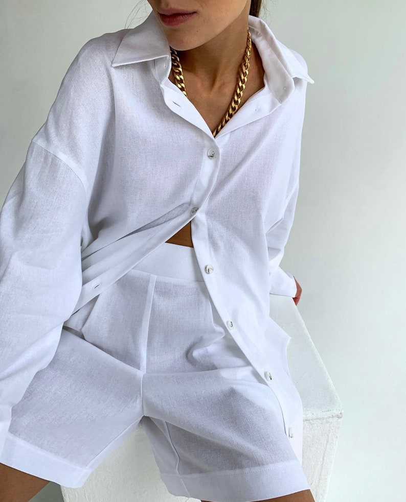 Pode incluir: Um conjunto de camisa e cal&ccedil;&otilde;es de linho branco. A camisa tem um colarinho cl&aacute;ssico e mangas compridas. Os cal&ccedil;&otilde;es t&ecirc;m um corte descontra&iacute;do e fecho de bot&atilde;o.