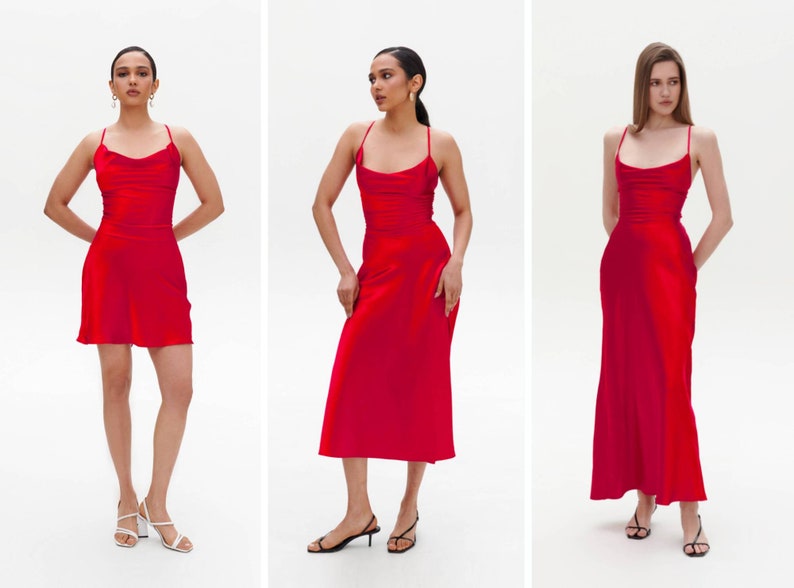 Puede incluir: Tres mujeres con vestidos de sat&eacute;n rojo de diferentes longitudes. Los vestidos tienen un cuello de pico y tirantes finos. Las mujeres est&aacute;n de pie sobre un fondo blanco.