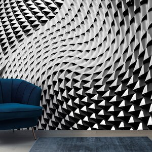 May include: A black and white abstract geometric pattern wallpaper with a blue armchair in the foreground. The pattern is made up of repeating triangles that create a wave-like effect.