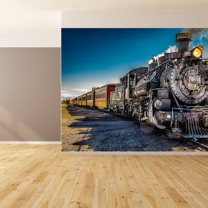 May include: A vintage steam locomotive train with a black engine and red and yellow passenger cars. The train is moving forward on a track with a blue sky and white clouds in the background.