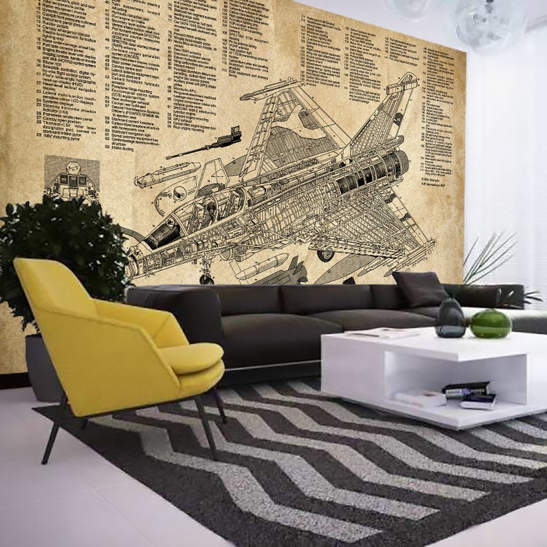 May include: A black and white line drawing of a fighter jet with detailed internal components. The drawing is on a vintage-style paper background with text labels. The jet is in mid-air with its wings spread out. The drawing is framed by a black couch and a yellow armchair in a living room setting.