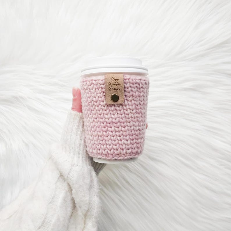 May include: A white ceramic mug with a black handle and the text "But First, Coffee" in a black, handwritten-style font. The mug is on a white surface.