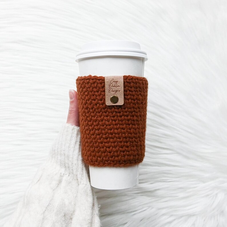May include: A white ceramic mug with a colourful floral design. The mug has a handle and a wide opening. The flowers are in shades of pink, purple, and yellow. The mug is likely for hot drinks.