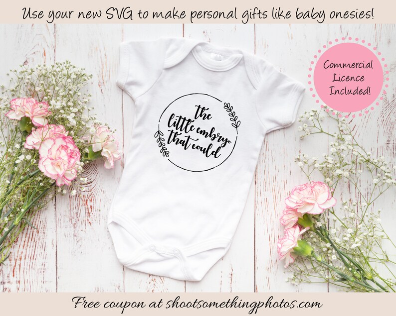 Op de afbeelding: Witte babyromper met de tekst "the little embryo that could" in een zwart cirkelvormig ontwerp. De afbeelding bevat bloemen en de tekst "Use your new SVG to make personal gifts like baby onesies!" en "Commercial Licence Included!"