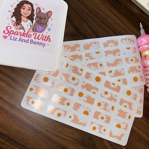 May include: A collection of daisy-themed stickers with a peach background, a white box with the text "Sparkle With Liz And Benny", and a pink and yellow pen-like tool with a diamond-like design.