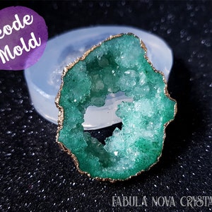 Può includere: Uno stampo per geodi verde con un bordo dorato. Lo stampo è realizzato in silicone ed è progettato per creare oggetti in resina a forma di geodi.