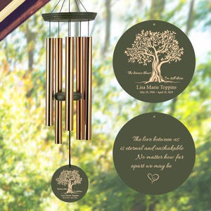 May include: A green and brown wind chime with a tree design and the text "The breeze blows I'm still there Lisa Marie Toppins May 20, 1964 - April 18, 2024" on the top disc. The bottom disc has the text "The love between us is eternal and unshakable No matter how far apart we may be".