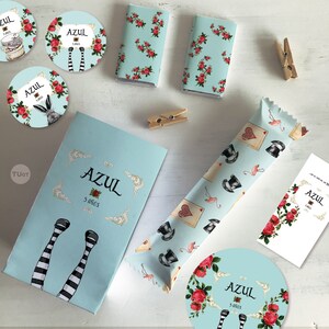 Puede incluir: Un conjunto de favores de fiesta para una fiesta de cumplea&ntilde;os con un tema caprichoso de Alicia en el Pa&iacute;s de las Maravillas. Los favores incluyen barras de chocolate, envoltorios de dulces y pegatinas redondas con el nombre "Azul" y la edad "5 anos".